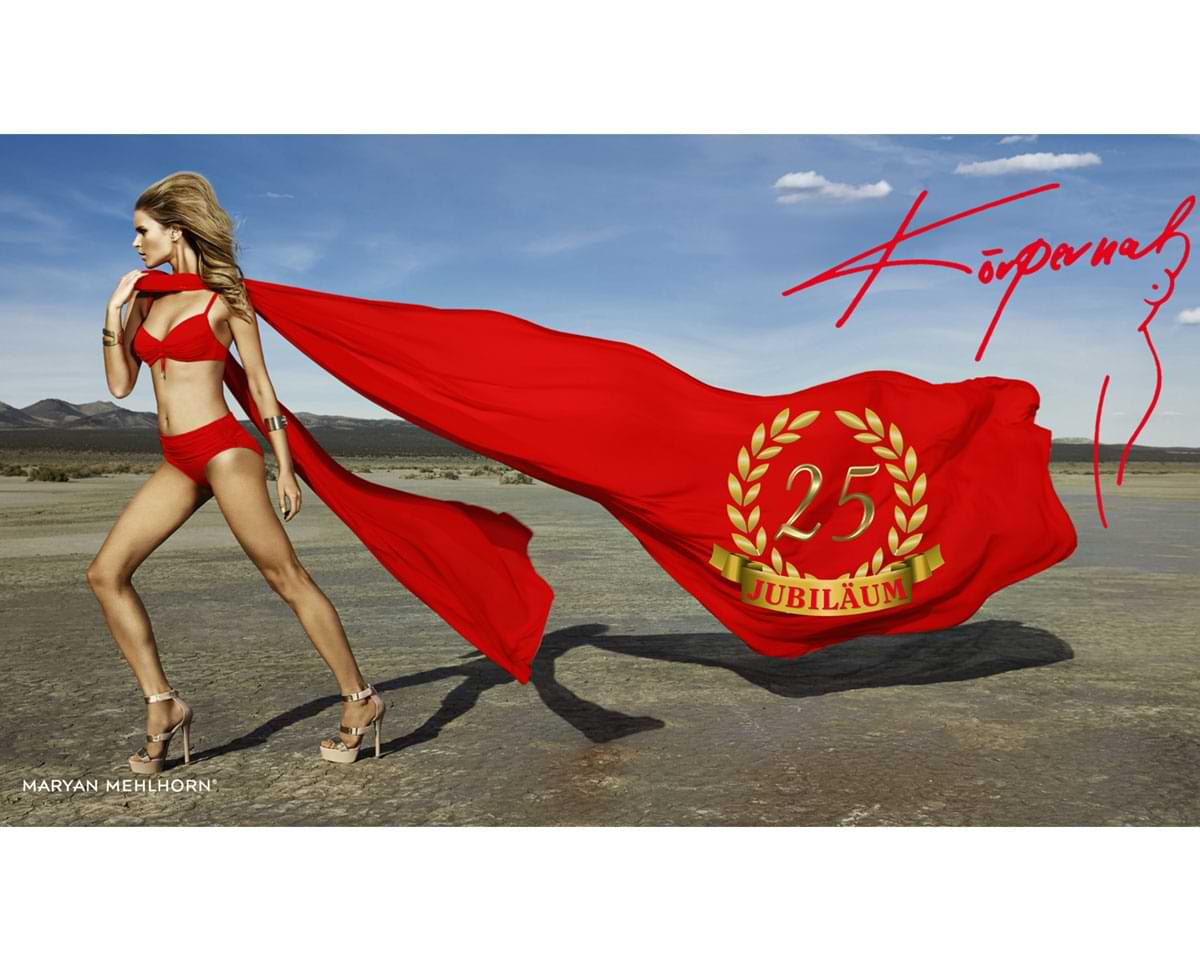 Model von Maryan Mehlhorn trägt rote Dessous mit 25 Jahre Jubiläum Symbol.